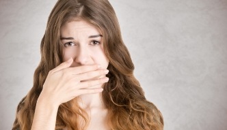 Brunette woman covering her mouth with her hand