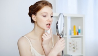 Woman looking at her mouth in mirror