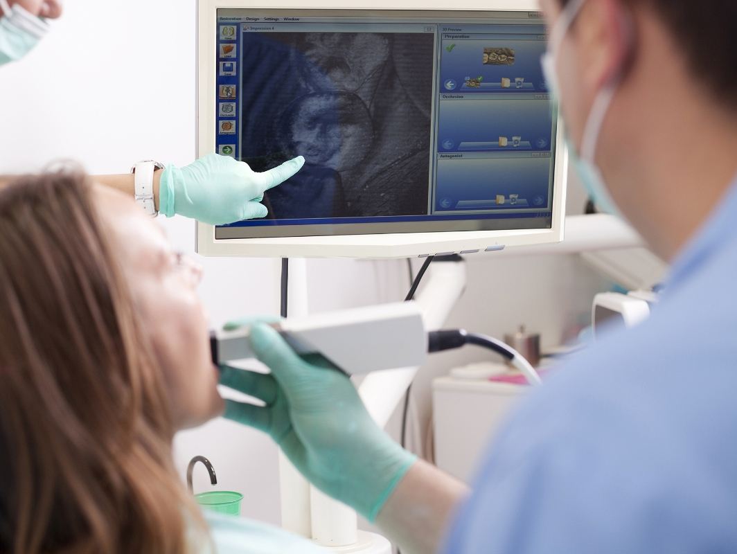 Dentist showing a patient a close up image of their tooth