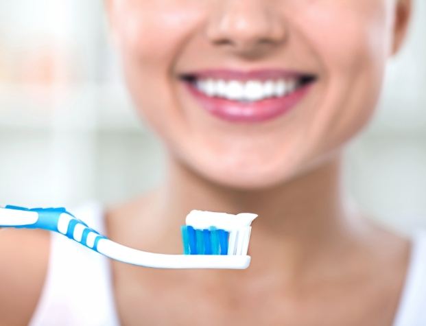 Smiling person holding toothbrush