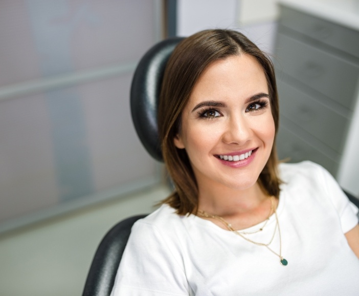 Woman in dental chair smiling after restorative dentistry in Westerville