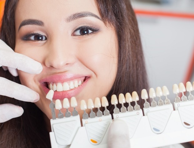 Cosmetic dentist finding the right shade of veneer for a patient
