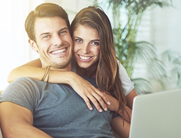 Smiling man and woman with laptop
